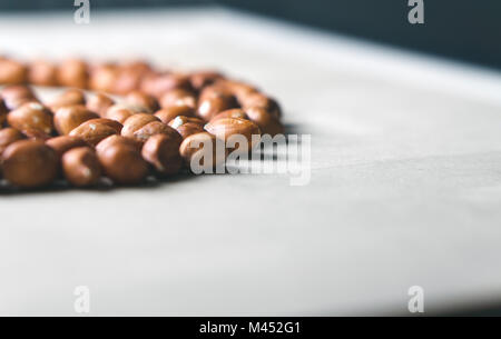 Erdnüsse auf hölzernen Tisch. Bündel von Muttern. Gruppe von Erdnüssen. Kostenlos leere Platz für Text. Stockfoto