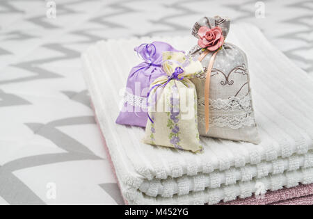 Drei Lavendel Duft Beutel auf Handtücher. Kleine Säckchen auf Schlafzimmer Bett. Duft Beutel für Frische. Dekoration, Ausstattung und Zubehör. Stockfoto