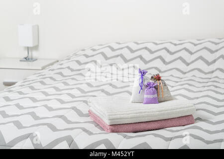 Dekoration Zubehör und hellen skandinavischen Design. Kleine Säckchen und Lavendel Beutel auf Handtücher auf dem Bett. Beutel gefüllt mit Lavendel. Stockfoto