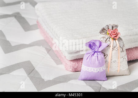 Zwei kleine Säckchen stützte sich auf zwei Handtücher auf dem Bett. Duftende lavendel Säckchen für Innenarchitektur und Lagerung. Dekorative Taschen mit netten Geruch. Stockfoto