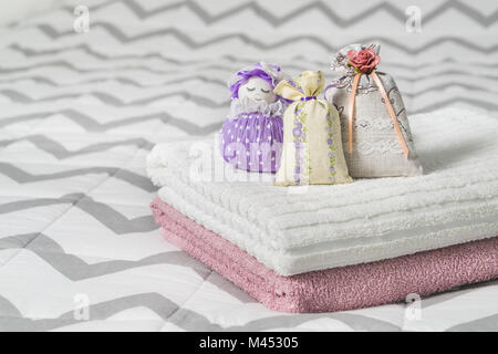 Kleine Säckchen und duftenden Tasche Abbildung eines Mädchens. Beutel gefüllt mit Lavendel im Schlafzimmer. Handtücher auf dem Bett. Duft Beutel für Frische. Dekoration. Stockfoto