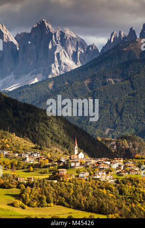 Eine herbstliche Ansicht von Teis, einem kleinen Dorf im Villnössertal mit der Geisler Gruppe im Hintergrund, Provinz Bozen, Südtirol, Trentino Alto Adig Stockfoto