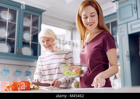Junge Frau und ihre Mutter die Salat zusammen Stockfoto