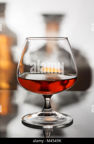 Ein Glas stark aromatische Brandy auf dem Hintergrund der zwei Flaschen Stockfoto