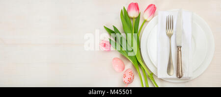 Ostern Tisch mit rosa Tulpen auf weißem Holz- Hintergrund. Ansicht von oben, Banner, Platz für Text Stockfoto
