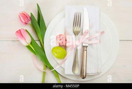 Ostern Tisch mit rosa Tulpen auf weißem Holz- Hintergrund. Ansicht von oben Stockfoto