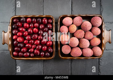 Preiselbeeren weiter Früchte - zwei quadratische, symmetrisch angeordneten Obstschalen zu Lychee Stockfoto