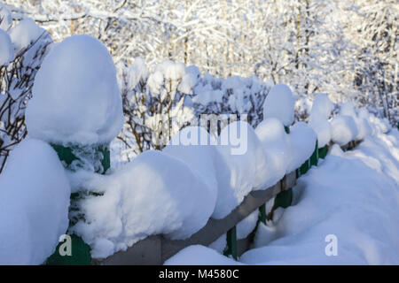 Schnee Kappen auf die dekorativen Zaun nach einem starken Schneefall. Eine ungewöhnliche Form von Schnee. Interessante Fotos für die Website, über die Natur, Parks und der Jahreszeiten. Stockfoto
