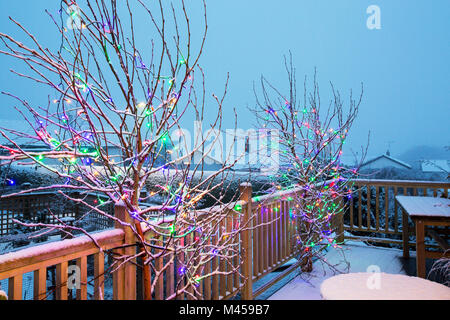 Weihnachtsbeleuchtung auf einem Balkon eines Hauses in Ambleside im Schnee. Stockfoto