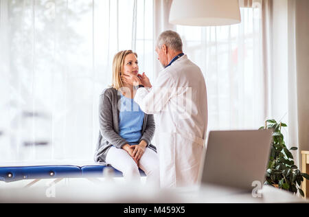 Leitender Arzt der Prüfung einer jungen Frau im Büro. Stockfoto