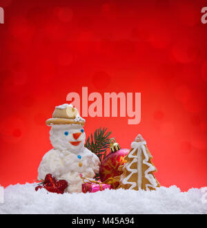 Weihnachtsplätzchen mit Schneemann auf rotem Hintergrund. Stockfoto