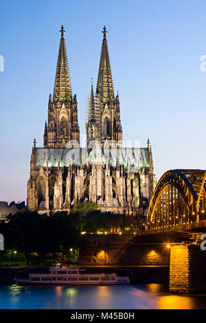 Der berühmte Kölner Dom mit Hohenzollernbrücke und einem der vielen Ausflugsschiffe am Rhein. Stockfoto