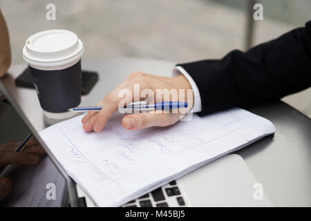 Junge Stadt Geschäftsmann Schreibarbeit tun Sidewalk Cafe, in der Nähe Stockfoto