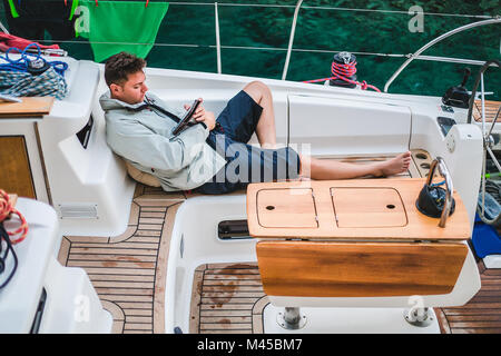 Man entspannen an Bord der Yacht an digitalen Tablet suchen, Kroatien Stockfoto