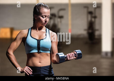 Zusammengesetztes Bild Fit Frau Ausübung durch Anheben der Hantel Stockfoto