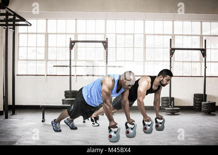 Zusammengesetztes Bild starke Freunde mit Kettlebells zusammen Stockfoto