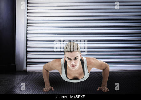 Zusammengesetztes Bild der muskulöse Frau doing Push-ups Stockfoto