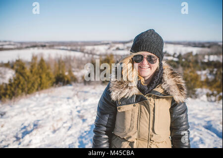 Porträt der jungen Frau, die in der verschneiten Landschaft Stockfoto