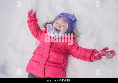 Junge Mädchen machen Schnee Engel im Schnee, close-up Stockfoto