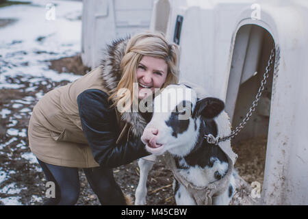 Porträt der jungen Frau mit Kuh, im Winter Landschaft Stockfoto