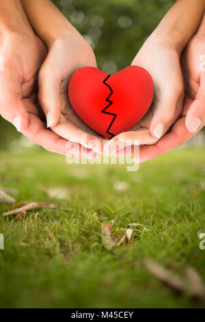 Zusammengesetztes Bild des Paares gebrochenes Herz in den Händen halten Stockfoto