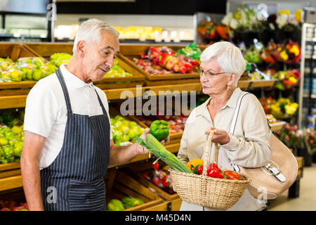 Ältere Kunden und Arbeitnehmer diskutieren Gemüse Stockfoto