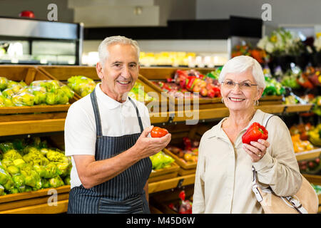 Ältere Kunden und Arbeitnehmer diskutieren Gemüse Stockfoto