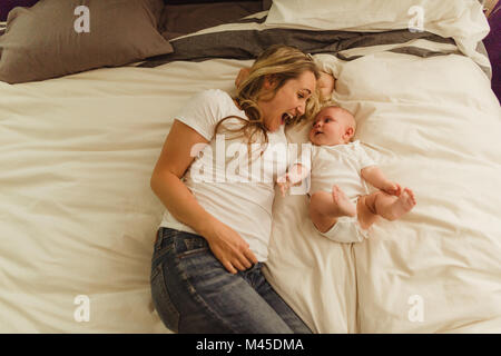 Ansicht der Frau und Tochter auf dem Bett liegend Stockfoto