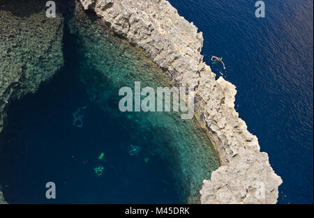 Einige Taucher und Schnorchler sind die Prüfung eines Underwater stone arch als blaue Loch in der Nähe des Azure Window auf Gozo, Malta bekannt. Stockfoto