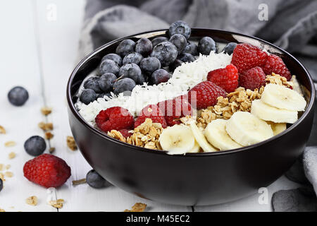 Frühstück Buddha Schüssel mit Chia pudding gefüllt, zuckerfrei Kokos, hausgemachtes Müsli, frische Heidelbeeren, Himbeeren oder Bananen. Extrem flache Dept Stockfoto