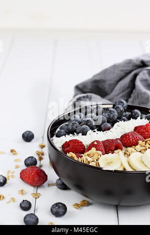 Frühstück Buddha Schüssel mit Chia pudding gefüllt, zuckerfrei Kokos, hausgemachtes Müsli, frische Heidelbeeren, Himbeeren oder Bananen. Extrem flache Dept Stockfoto