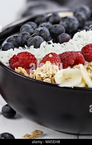 Frühstück Buddha Schüssel mit Chia pudding gefüllt, zuckerfrei Kokos, hausgemachtes Müsli, frische Heidelbeeren, Himbeeren oder Bananen. Extrem flache Dept Stockfoto