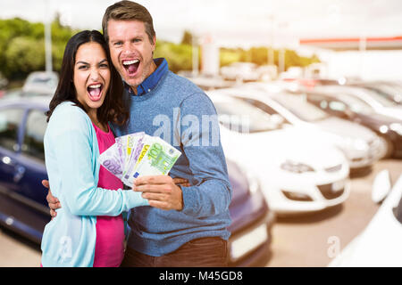 Zusammengesetztes Bild aufgeregt Paares halten Geld Stockfoto