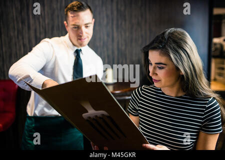 Attraktive Frau, die Bestellung auf den Kellner aus dem Menü Stockfoto