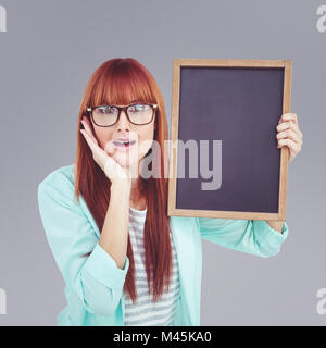 Zusammengesetztes Bild des Lächelns Hipster Frau Holding Tafel Stockfoto