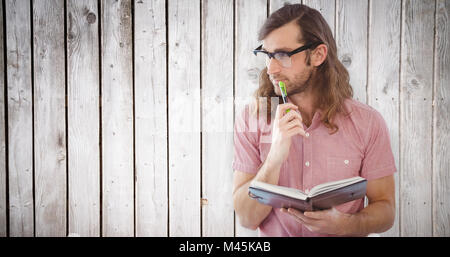 Zusammengesetztes Bild nachdenklich Hipster mit Stift und Buch Stockfoto