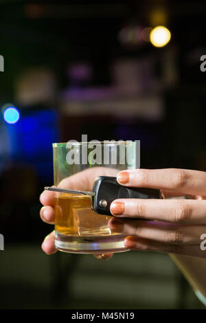 Frau mit einem Glas Whiskey und Auto Schlüssel Stockfoto