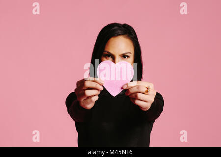 Frau in Schwarz mit rosa Herzen die Hälfte Ihr Gesicht, be my valentine Stockfoto