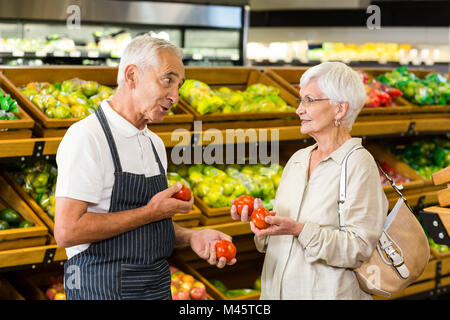 Ältere Kunden und Arbeitnehmer diskutieren Gemüse Stockfoto