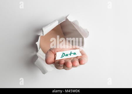 Zusammengesetztes Bild von Hand durch Papier platzen Stockfoto