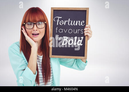 Zusammengesetztes Bild des Lächelns Hipster Frau Holding Tafel Stockfoto