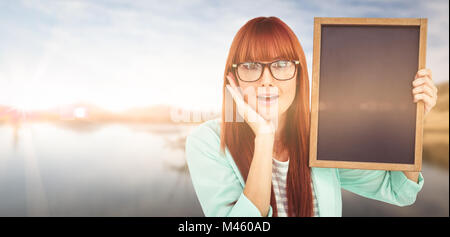 Zusammengesetztes Bild des Lächelns Hipster Frau Holding Tafel Stockfoto