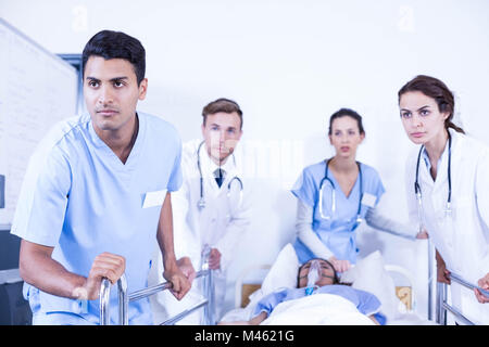 Betroffenen Ärzte stehen in der Nähe von Patienten auf Bett Stockfoto