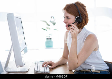 lächelnde Hipster-Business-Frau trägt einen Kopfhörer Stockfoto