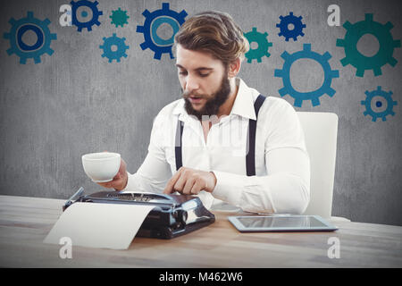 Zusammengesetztes Bild Hipster halten Kaffee arbeiten auf Schreibmaschine Stockfoto