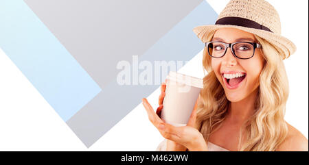 Zusammengesetztes Bild des wunderschönen lächelnden blonden Hipster präsentieren Take-away-Becher Stockfoto