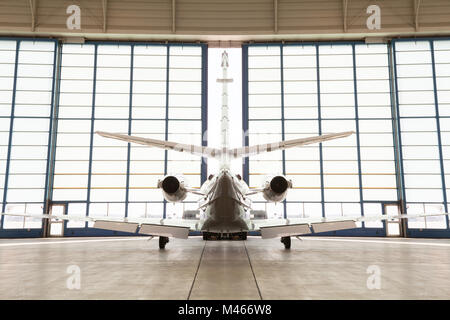 Private Corporate Jet in einem Hangar abgestellten Stockfoto
