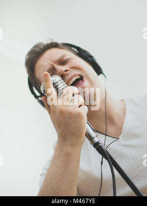 Stattlicher Mann mit der Aufnahme eines Songs. Am Mikrofon. Platz für Ihren Text. Stockfoto