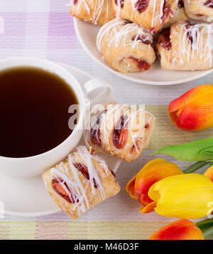 Erdbeere Gebäck und Kaffee mit bunten Tulpen auf einem Tisch Stockfoto