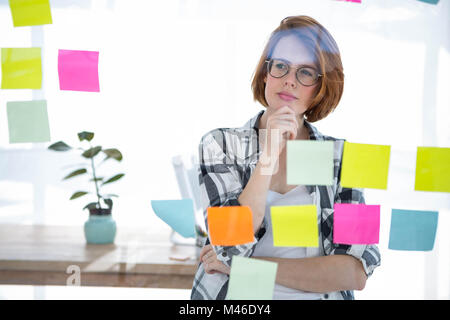 nachdenklich Hipster Frau brainstorming über Noten Stockfoto